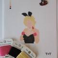 Threaded & Tipsy hand-painted needlepoint canvas featuring a faceless figure of a blonde woman in a black strapless outfit with pink gloves, a white collar, and black bunny ears. A painted color guide is visible in the upper left corner, and the initials 