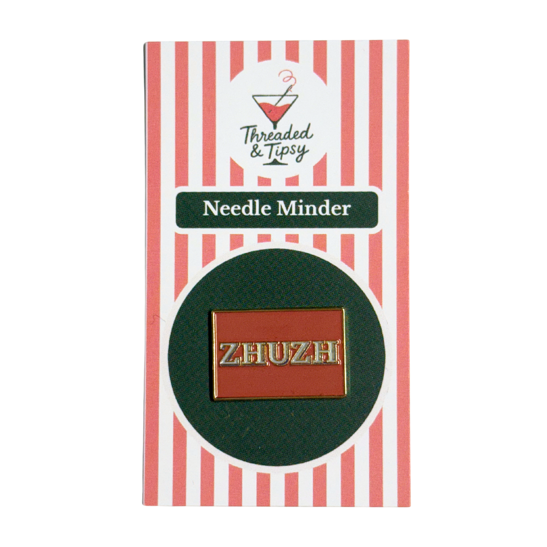 Zhuzh needle minder on striped packaging with 'Threaded & Tipsy' branding
