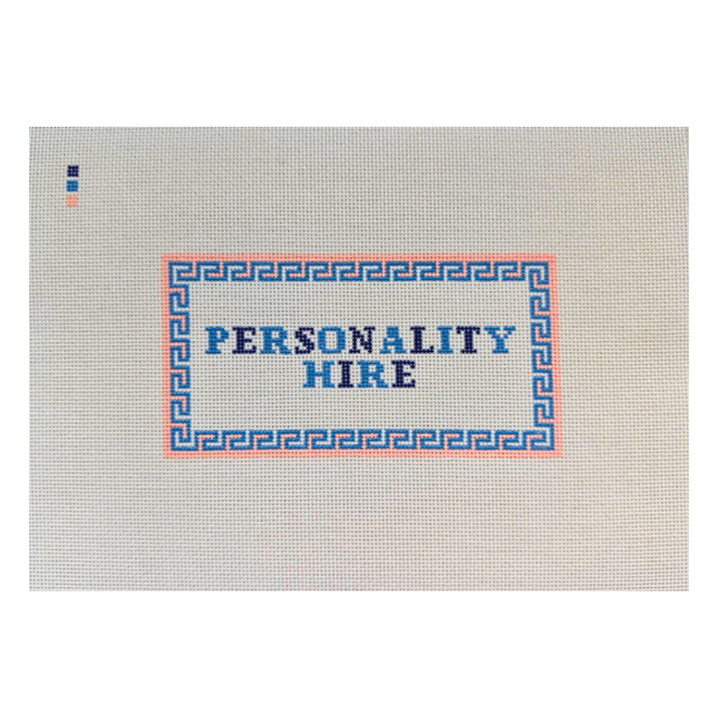Threaded & Tipsy hand-painted needlepoint canvas featuring the phrase “PERSONALITY HIRE” in bold blue and navy block letters. The text is framed by a pink and blue geometric border. A small painted color guide with three swatches—navy, blue, and peach—is located in the upper left corner. The canvas is unstitched and presented on a plain white background.