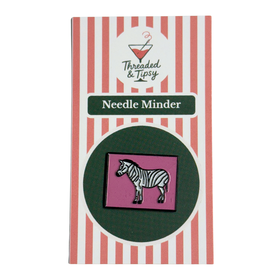 Zebra needle minder on striped packaging with 'Threaded & Tipsy' branding